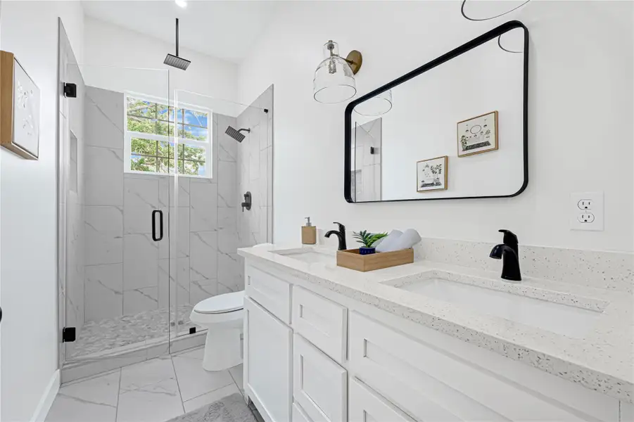 Luxurious secondary bathroom featuring a double vanity and a spacious walk-in shower.