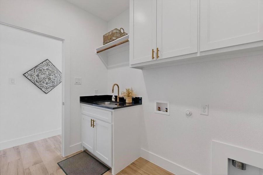 Laundry room featuring gas dryer hookup, cabinet space, light wood-type flooring, and washer hookup