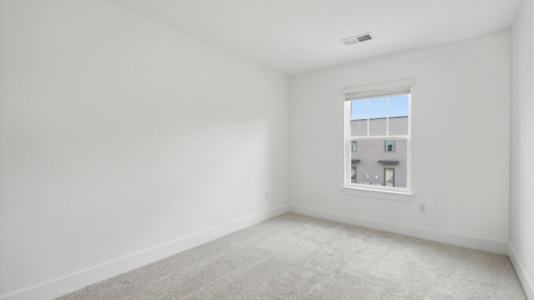 Inviting bedroom with tasteful finishes and a large window that creates a fresh, open ambiance