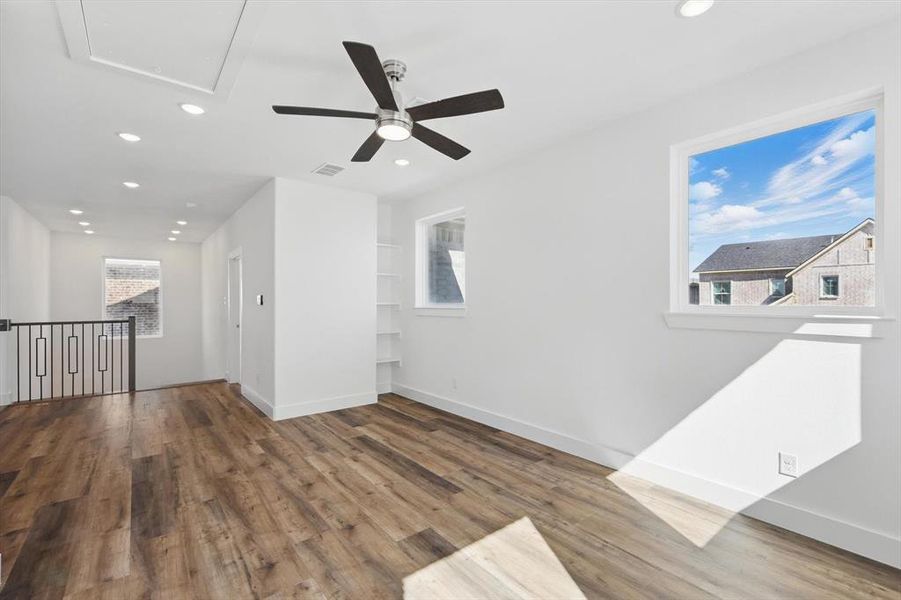 Spare room with recessed lighting, a healthy amount of sunlight, and wood finished floors