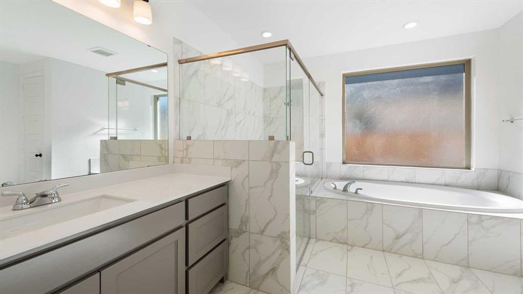 Bathroom featuring vanity and independent shower and bath