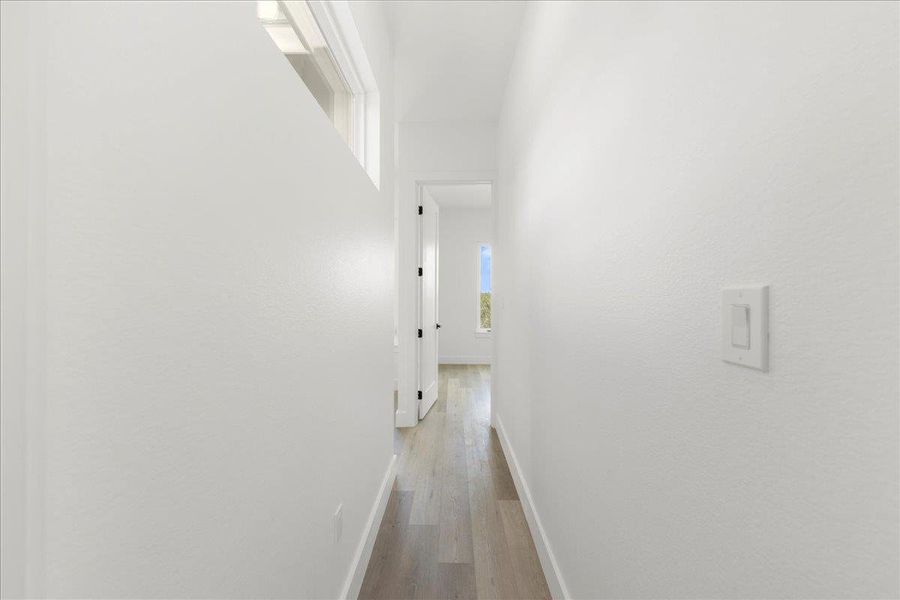 Hall featuring light wood-style flooring and baseboards Hall featuring light wood-style flooring and baseboards