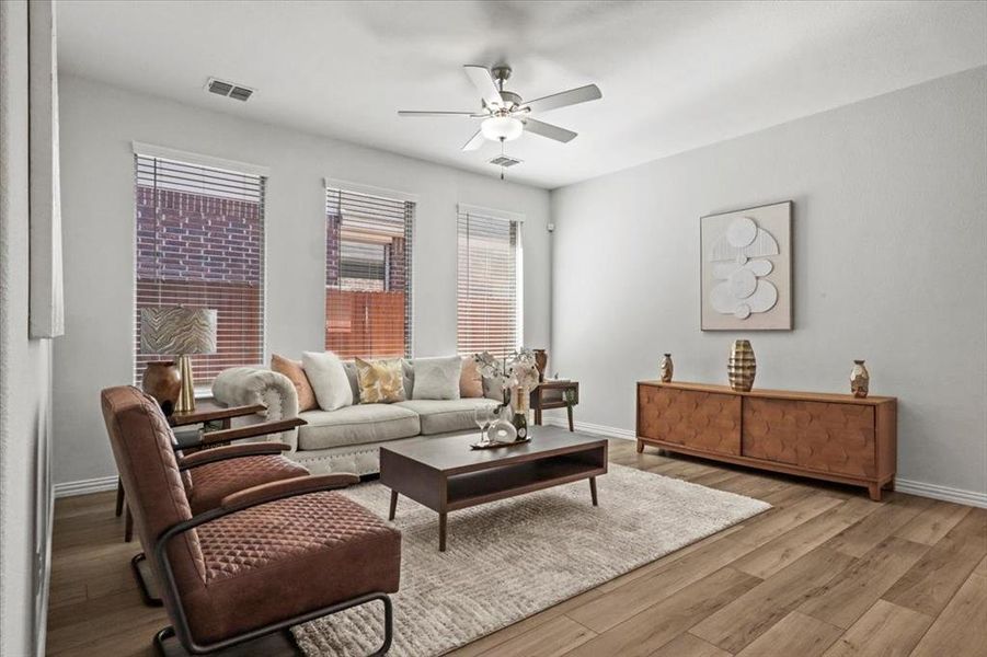 Living area with wood finished floors and a ceiling fan Living area with wood finished floors and a ceiling fan