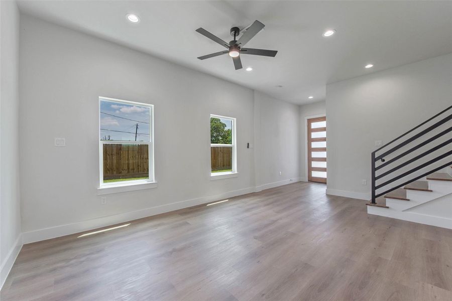 A view from the kitchen captures the seamless flow between the living room and entryway, while the staircase leads upstairs to the bedrooms, baths, and versatile flex space. A view from the kitchen captures the seamless flow between the living room and entryway, while the staircase leads upstairs to the bedrooms, baths, and versatile flex space.