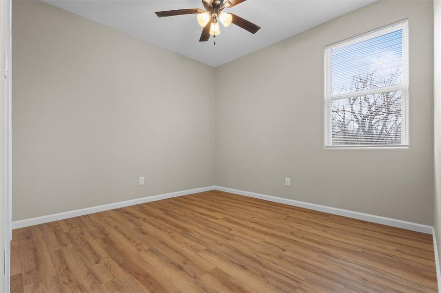Empty room with light wood-style flooring and ceiling fan