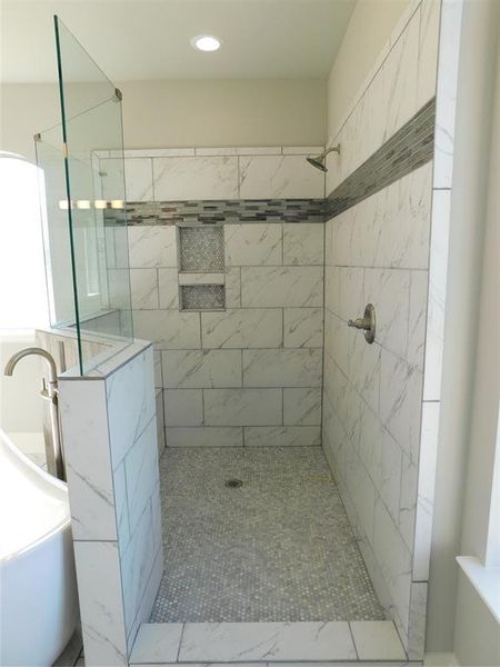 Spacious primary bathroom with huge walk in shower.