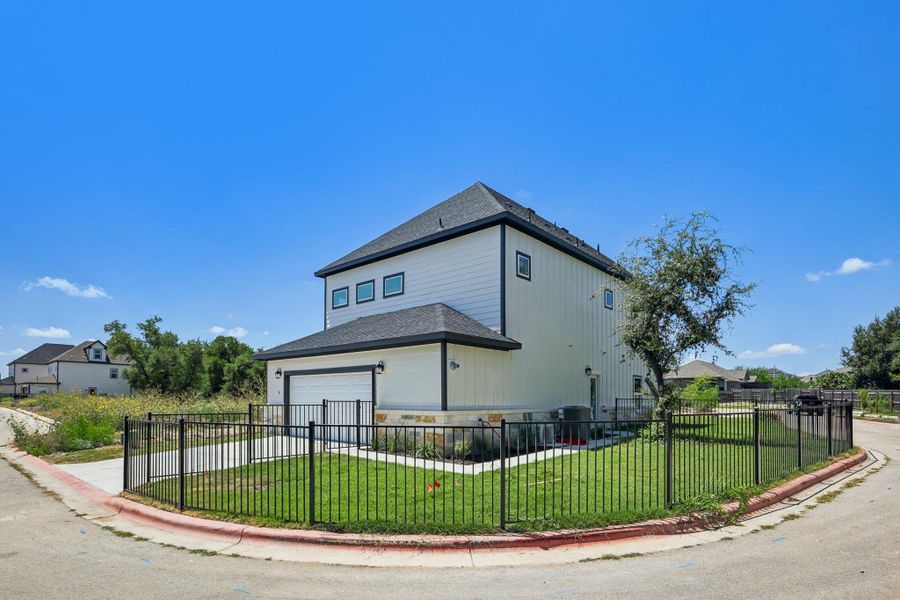 A fenced corner lot frames this modern two-story home featuring clean exterior architectural lines.
