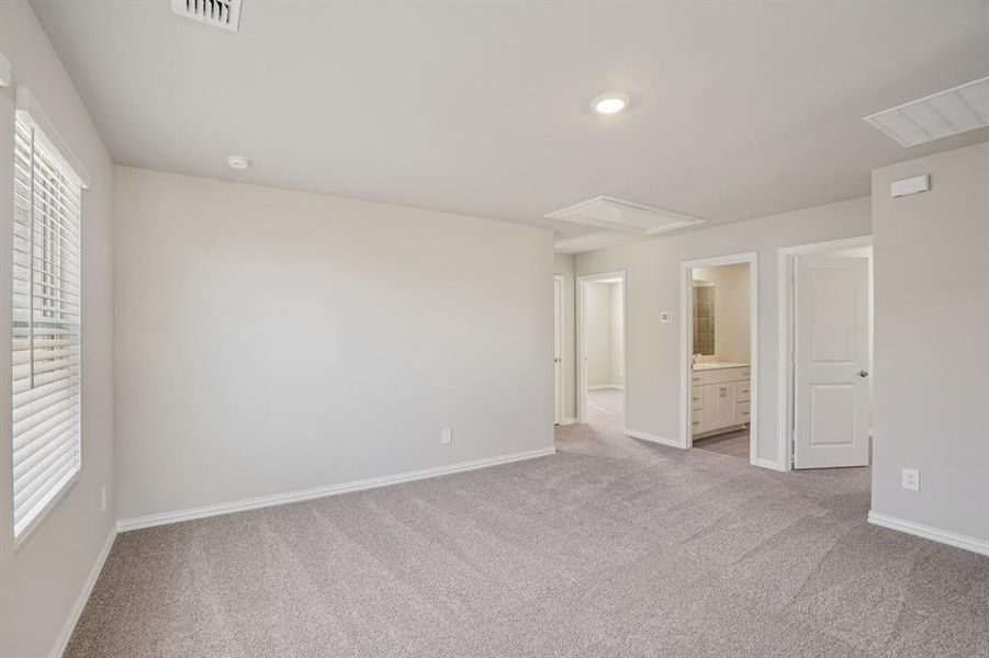 Unfurnished bedroom featuring ensuite bath and light carpet