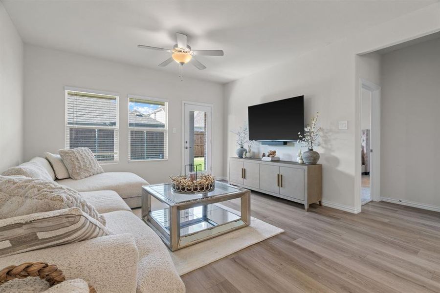 Living room with light wood-style flooring and ceiling fan Living room with light wood-style flooring and ceiling fan