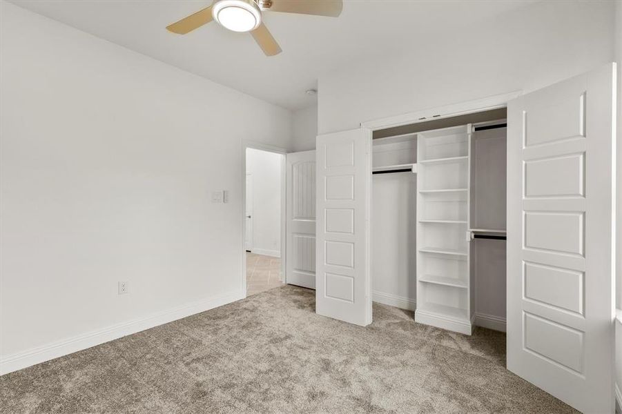 Unfurnished bedroom featuring a closet, light colored carpet, and ceiling fan