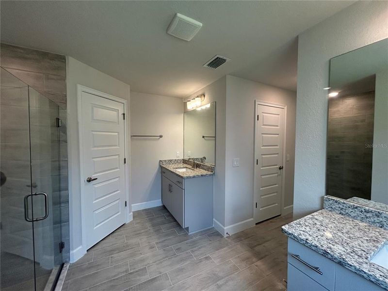 Dual Vanities in the Primary Bathroom with 3 cm Granite Countertops Dual Vanities in the Primary Bathroom with 3 cm Granite Countertops