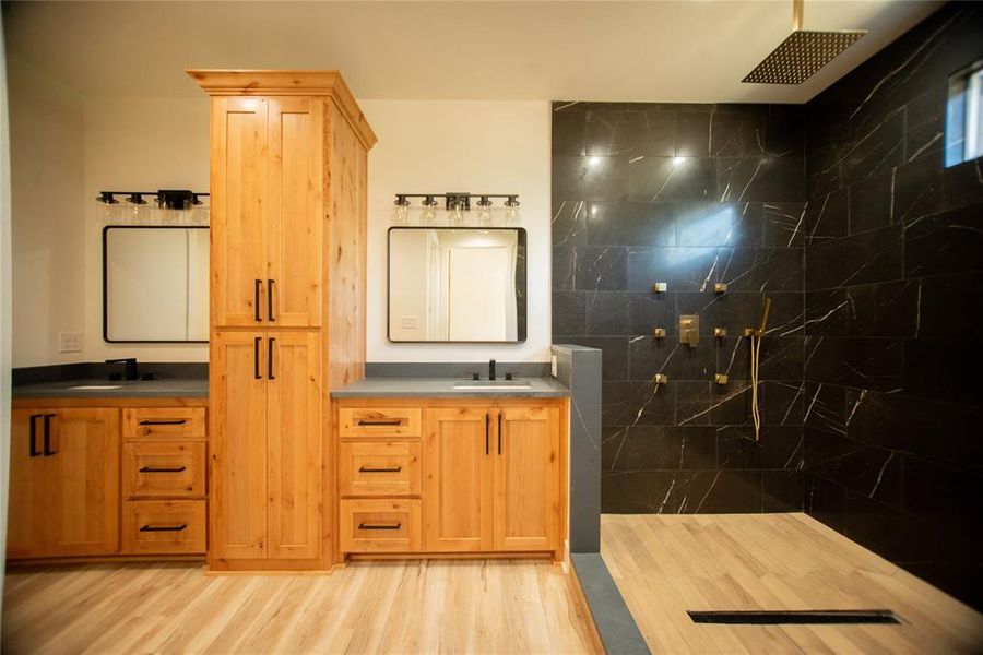 Bathroom with vanity, a walk in shower, and wood finished floors Bathroom with vanity, a walk in shower, and wood finished floors