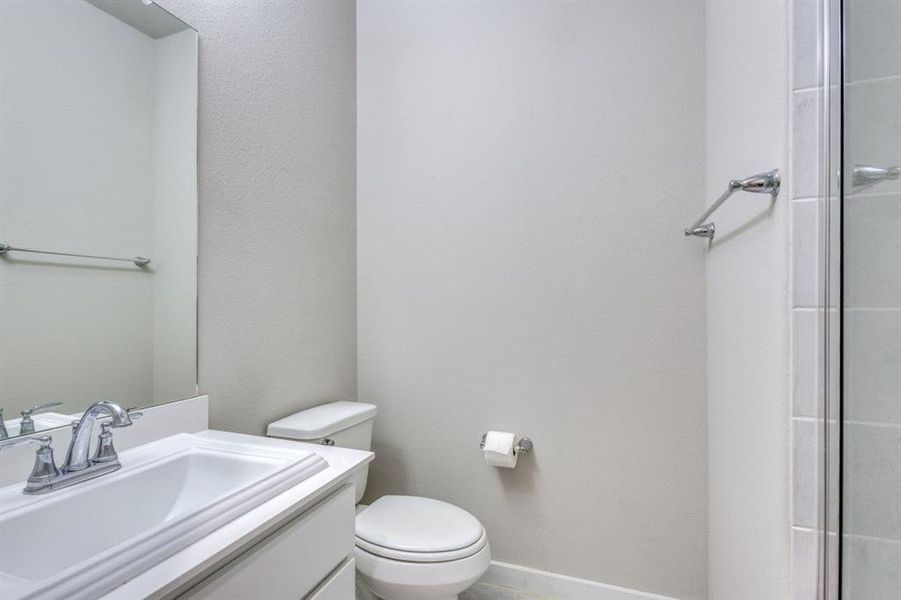 Bathroom with vanity, an enclosed shower, and a textured wall Bathroom with vanity, an enclosed shower, and a textured wall