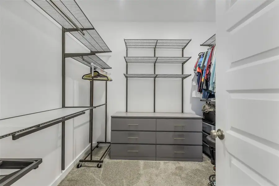 Expansive custom walk-in closet complete with built-in organization, shelving, and ample storage space.