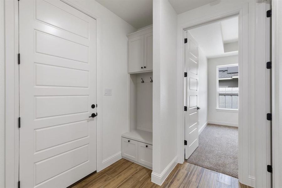 Mudroom featuring light wood-style flooring and baseboards