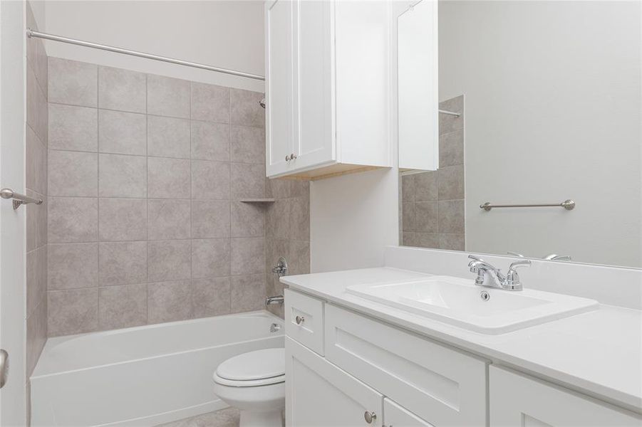 Full bathroom with vanity, toilet, and tiled shower / bath