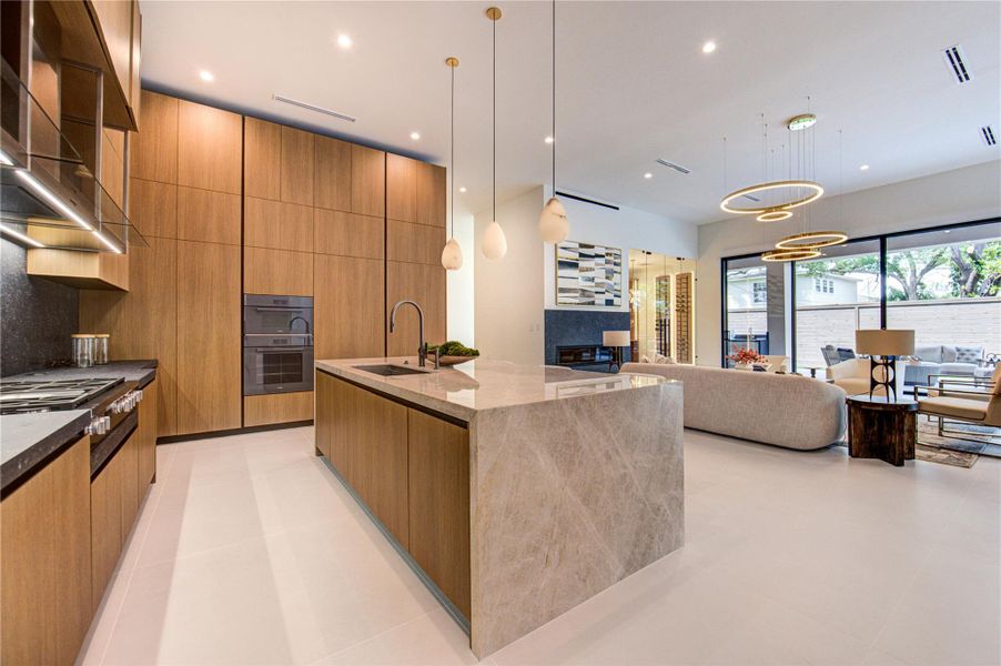 Miele-equipped kitchen with waterfall island and open connection to living.