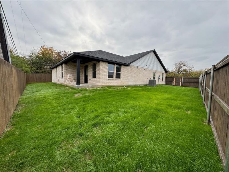 Back of house with cooling unit and a yard