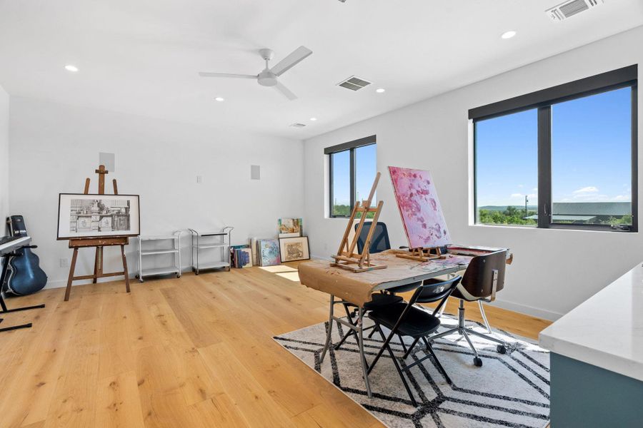 Light wood-finish flooring complements bright white walls and recessed lighting