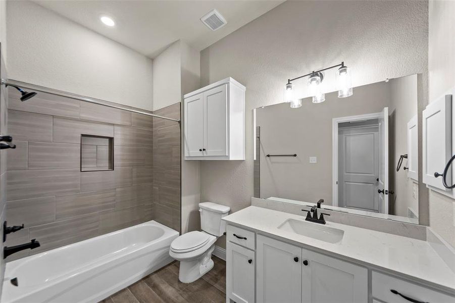 Full bathroom featuring a white vanity with a light-colored countertop, an integrated sink, and matte black fixtures