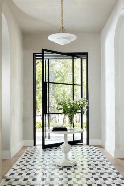 A custom-crafted front door paired with designer tile creates a striking and dramatic entrance. A custom-crafted front door paired with designer tile creates a striking and dramatic entrance.