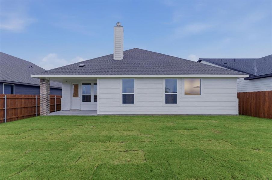 White siding exterior featuring a covered patio, brick accent column, a single chimney, and a dark shingle roof White siding exterior featuring a covered patio, brick accent column, a single chimney, and a dark shingle roof