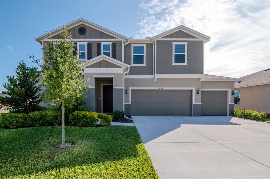 Front exterior of a new home in Riverstone, Land O' Lakes, FL, highlighting curb appeal (Image 1). Front exterior of a new home in Riverstone, Land O' Lakes, FL, highlighting curb appeal (Image 1).