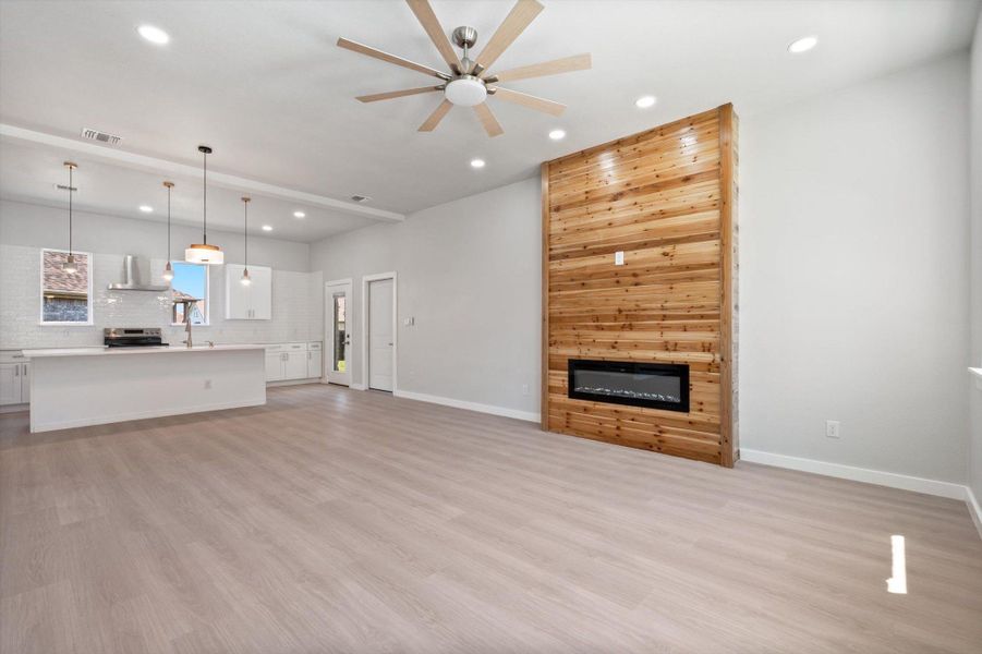 A striking cedar plank fireplace commands attention in this inviting open-concept living area with a bright kitchen.