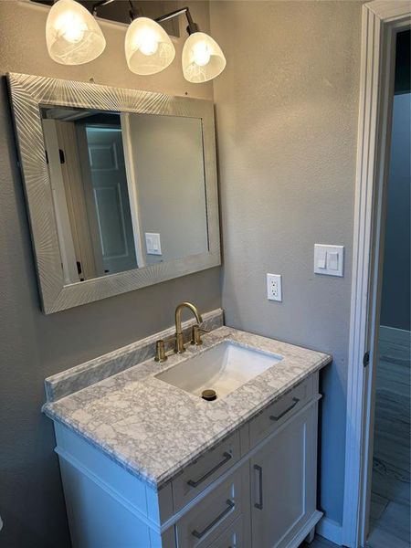 Bathroom with a textured wall and vanity Bathroom with a textured wall and vanity