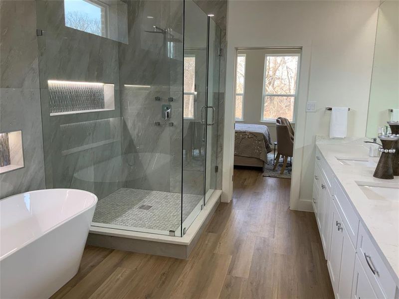 Ensuite bathroom with plenty of natural light, double vanity, a marble finish shower, and a freestanding bath Ensuite bathroom with plenty of natural light, double vanity, a marble finish shower, and a freestanding bath