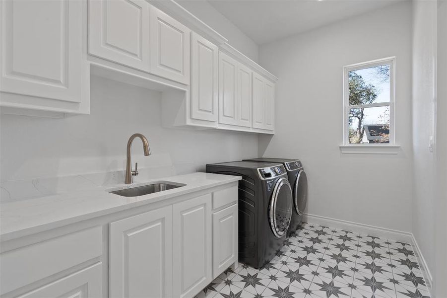 Laundry room with washing machine and dryer, sink, and cabinets