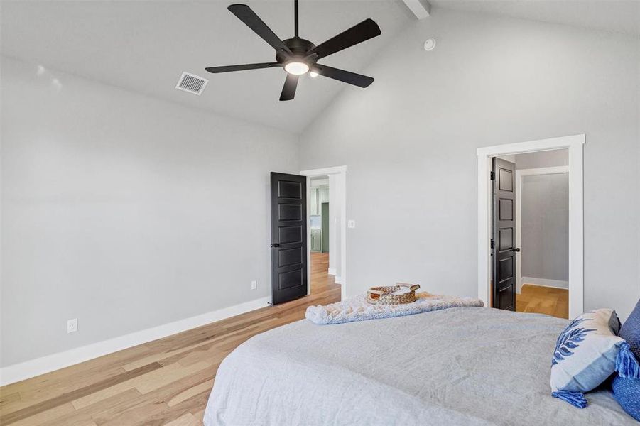 Bedroom featuring high vaulted ceiling, beam ceiling, light wood finished floors, and a ceiling fan Bedroom featuring high vaulted ceiling, beam ceiling, light wood finished floors, and a ceiling fan