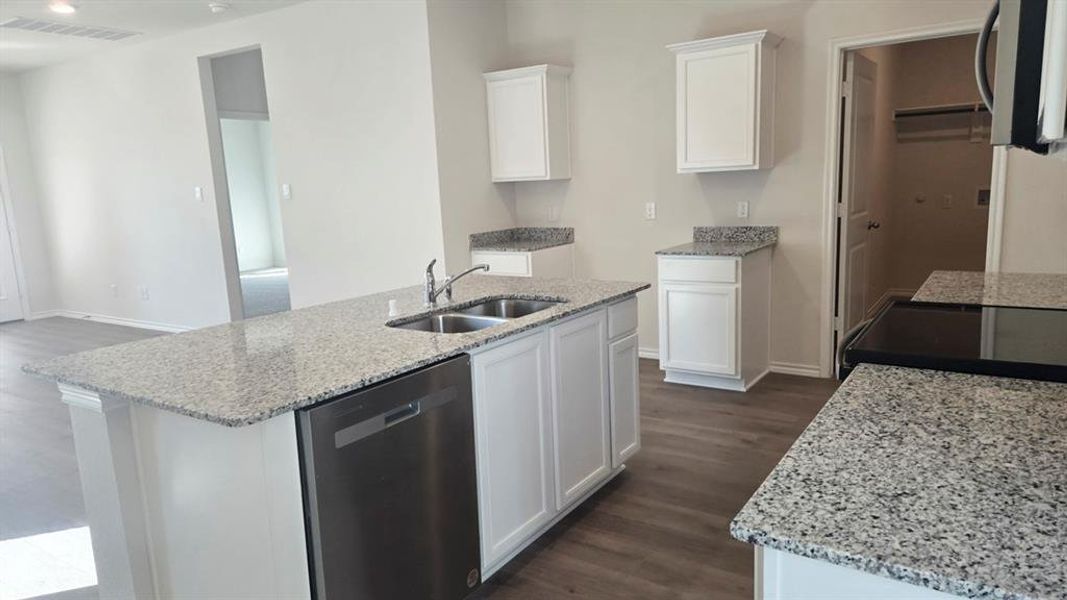 Kitchen with light stone counters, appliances with stainless steel finishes, and dark wood finished floors