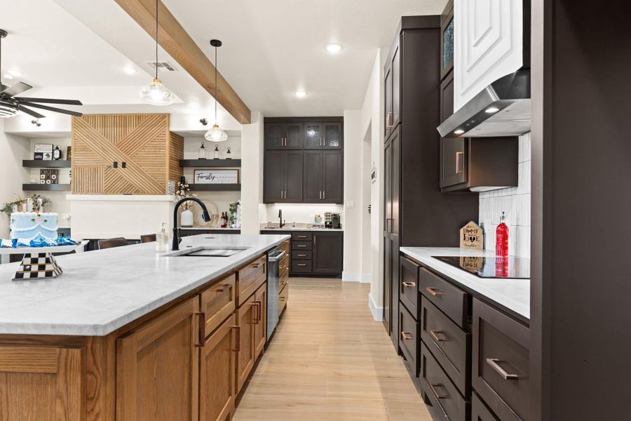 Kitchen featuring a sink, black electric cooktop, wall chimney exhaust hood, ceiling fan, and open shelves Kitchen featuring a sink, black electric cooktop, wall chimney exhaust hood, ceiling fan, and open shelves