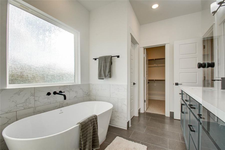 Freestanding acrylic tub in the primary bathroom. Model home photos, finishes and floor plan MAY VARY!