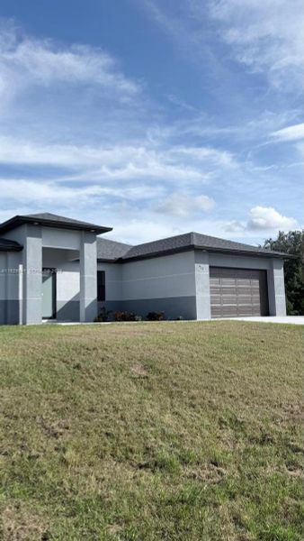 Front exterior of a new home in , Lehigh Acres, FL, highlighting curb appeal (Image 27). Front exterior of a new home in , Lehigh Acres, FL, highlighting curb appeal (Image 27).