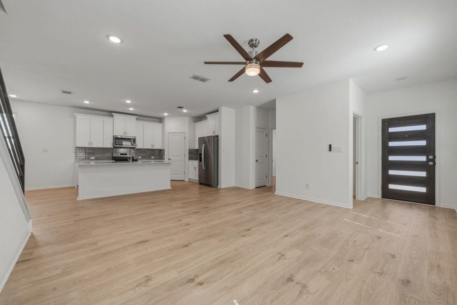 Unfurnished living room featuring a ceiling fan, light wood finished floors, and recessed lighting