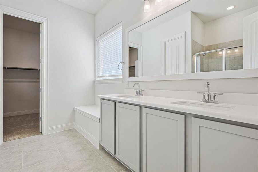 Bathroom featuring shower with separate bathtub, tile patterned flooring, and vanity