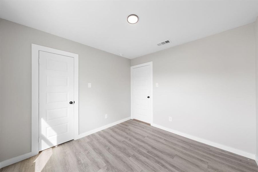 Unfurnished bedroom with light wood-type flooring and a closet Unfurnished bedroom with light wood-type flooring and a closet