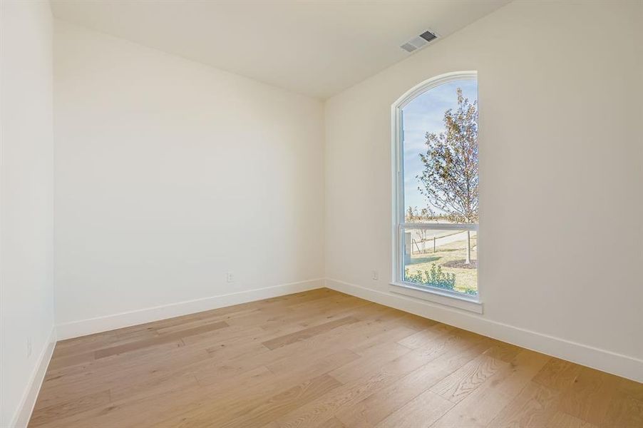 Empty room featuring baseboards and light wood finished floors