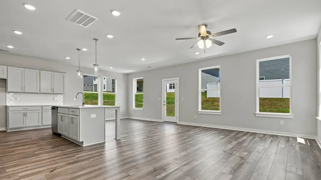 Elevated kitchen with various windows, island, ceiling fan, and other kitchen essentials Elevated kitchen with various windows, island, ceiling fan, and other kitchen essentials