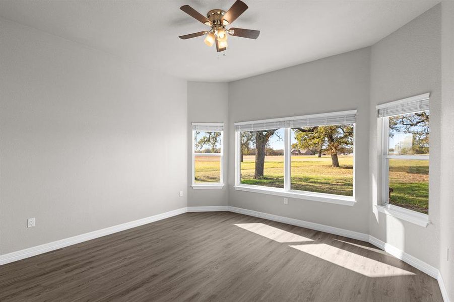 Empty room featuring dark wood-style flooring and ceiling fan