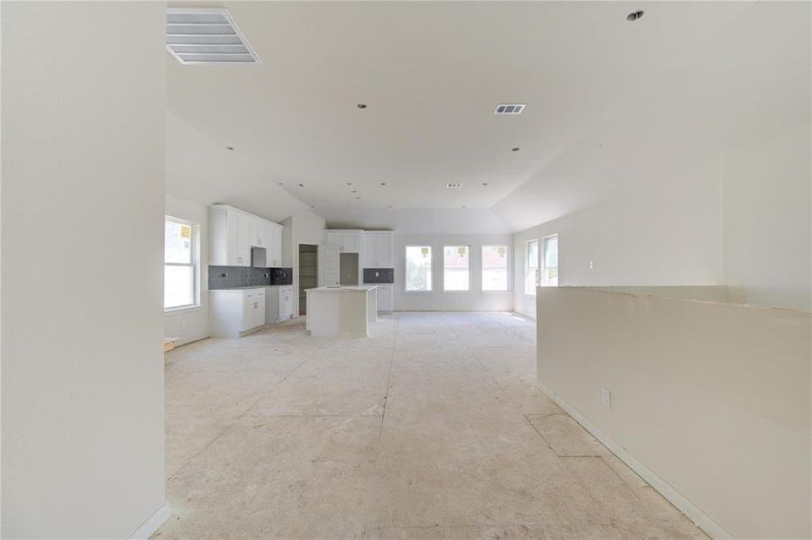 This expansive open living area seamlessly connects to the kitchen, creating a perfect environment for entertaining or family gatherings. The abundance of natural light and high ceilings enhance the spaciousness. **This image is from another Saratoga Home - Artemis floorplan.**