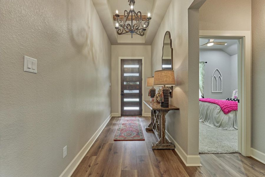 Looking back to the front of home you see a secondary room to the right. Note the plank-style front door with glass inserts allowing light while still maintaining privacy. Looking back to the front of home you see a secondary room to the right. Note the plank-style front door with glass inserts allowing light while still maintaining privacy.