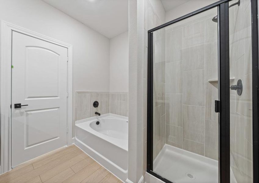 The master bathroom has a walk-in, glass shower and a garden tub.