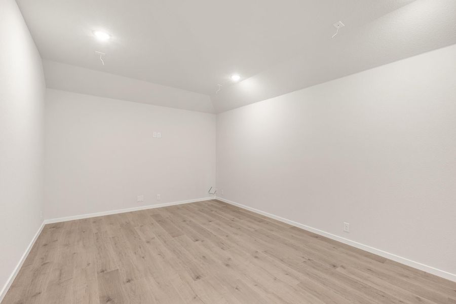 Empty room with light wood laminate floors, white walls, and recessed ceiling lights Empty room with light wood laminate floors, white walls, and recessed ceiling lights