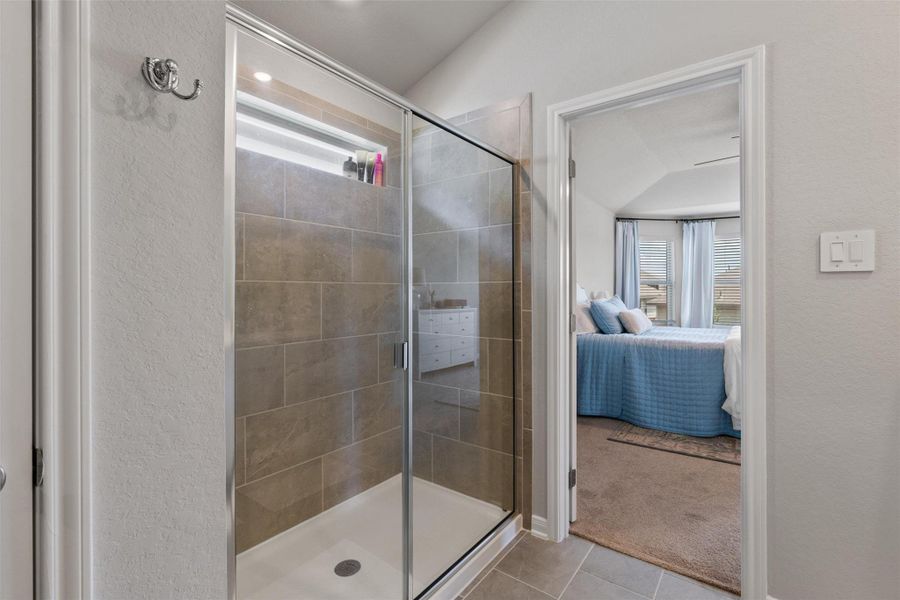 Frameless glass shower enclosure featuring large-format rectangular wall tiles and a recessed shower niche Frameless glass shower enclosure featuring large-format rectangular wall tiles and a recessed shower niche