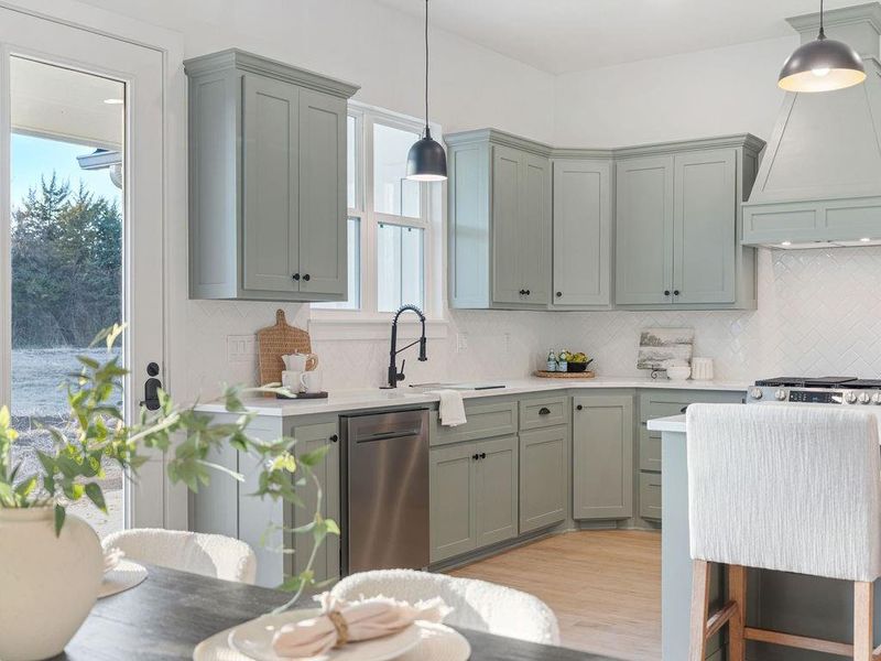 Kitchen with dishwasher, light wood-type flooring, decorative light fixtures, and backsplash