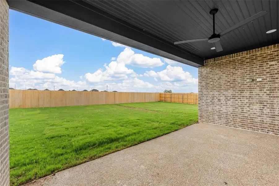 Fenced backyard featuring a patio area and a ceiling fan Fenced backyard featuring a patio area and a ceiling fan
