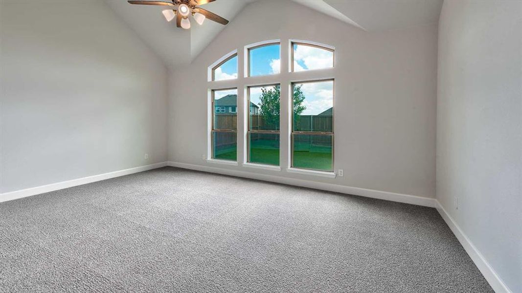 Spare room with high vaulted ceiling, ceiling fan, and carpet flooring